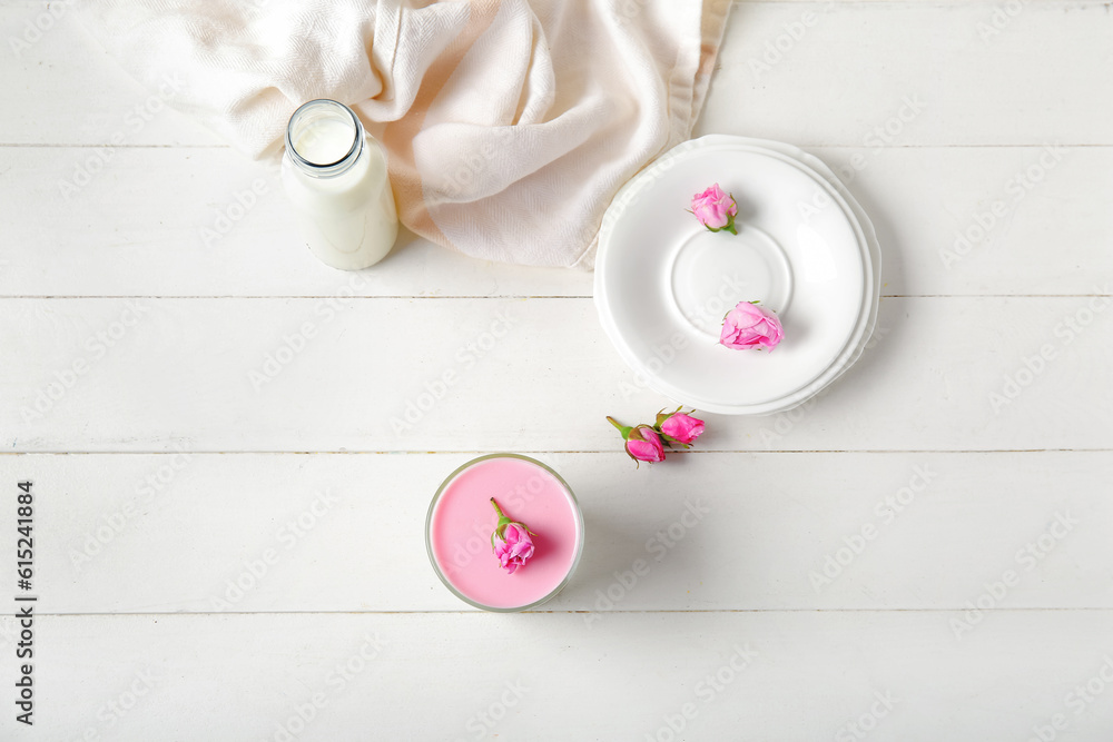 Glass panna cotta with beautiful pink rose flowers on white wooden table