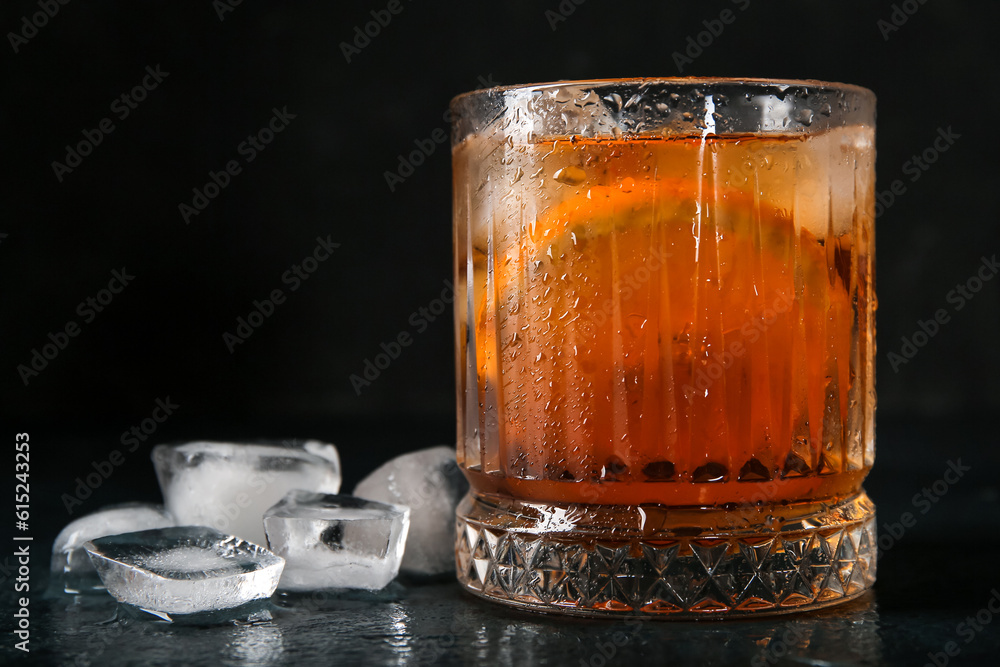 Glass of ice tea with orange on black background