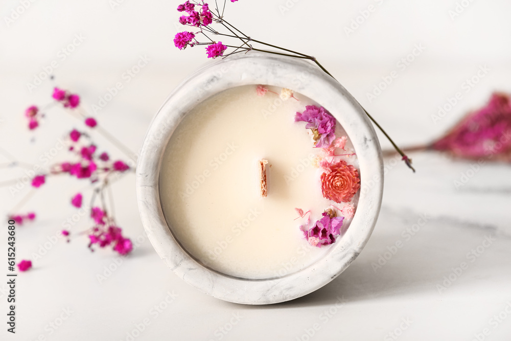 Holder with candle and flowers on white background