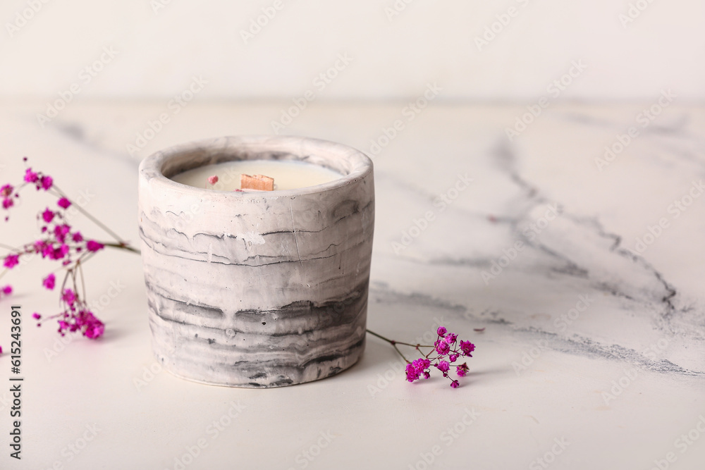 Holder with candle and flowers on white background