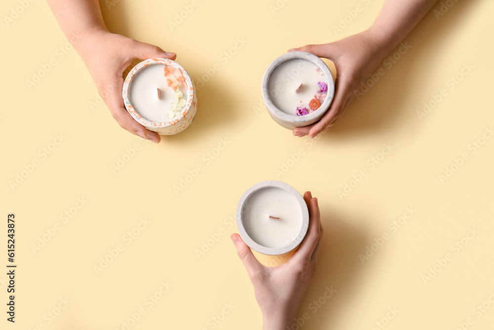 Women holding candles on yellow background