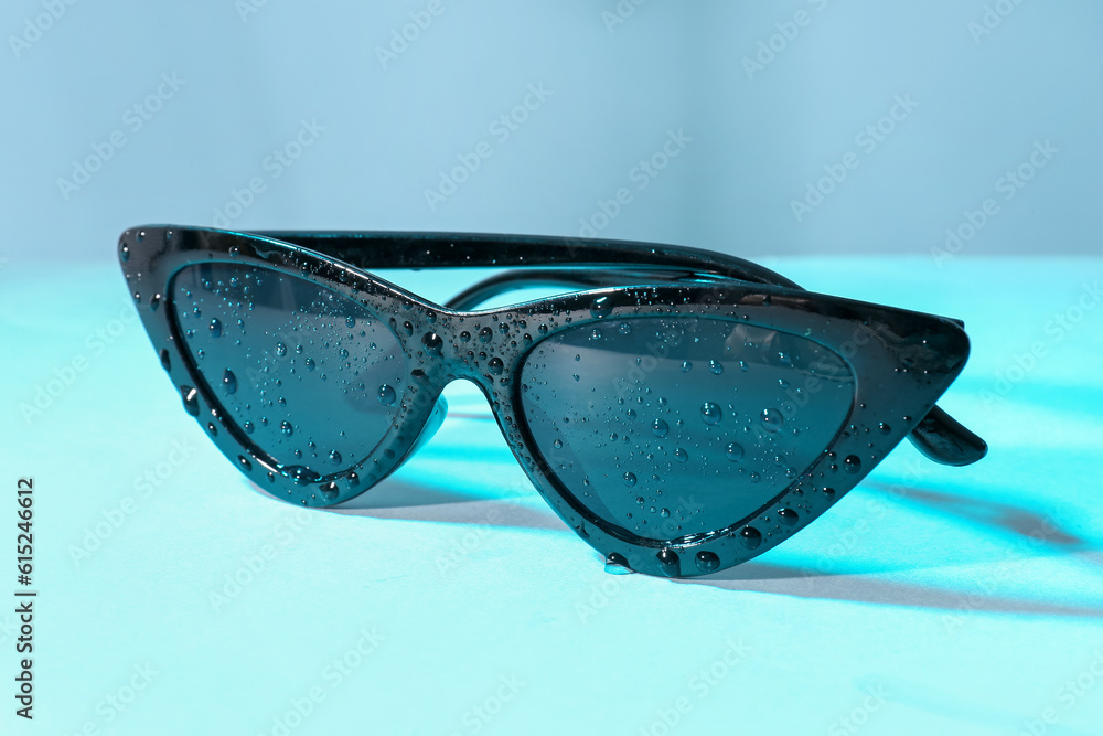 Stylish sunglasses on blue background