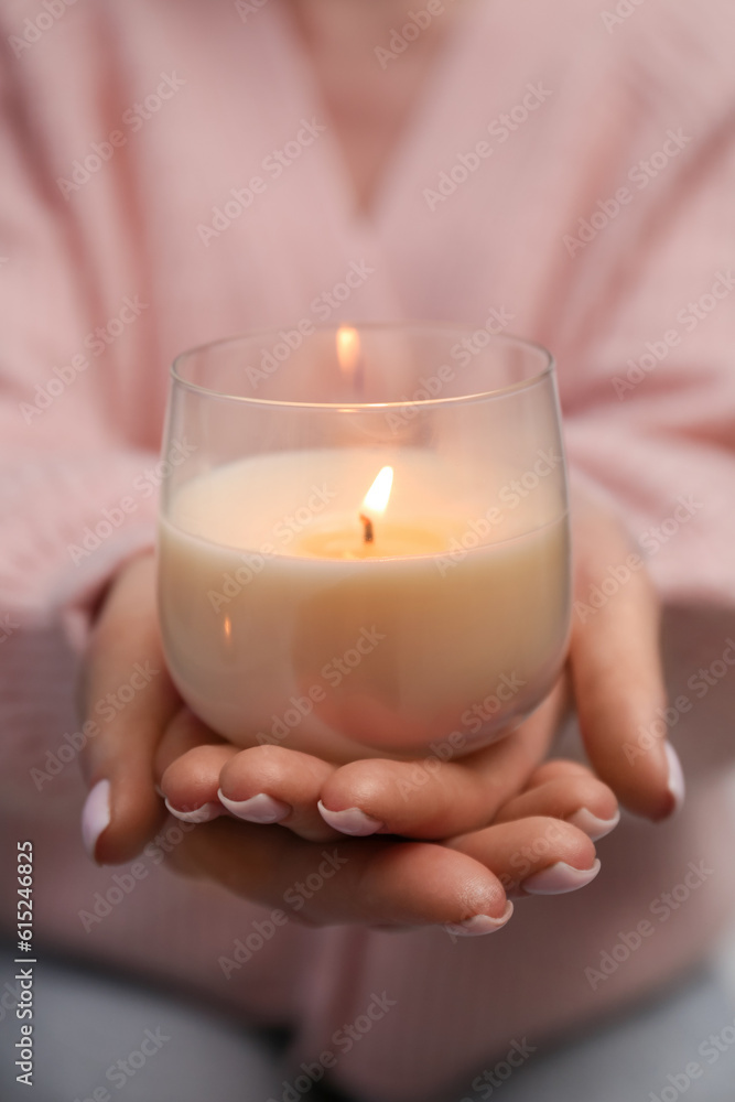 Woman with beautiful burning candle, closeup