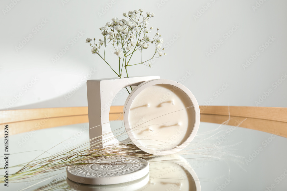 Gypsophila flowers and candle on mirror in room, closeup