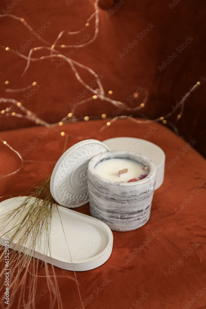 Holder with candle on fabric background, closeup