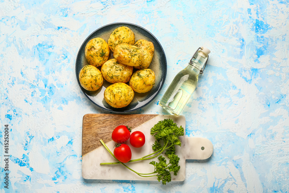 Plate of boiled baby potatoes with dill and parsley on blue background