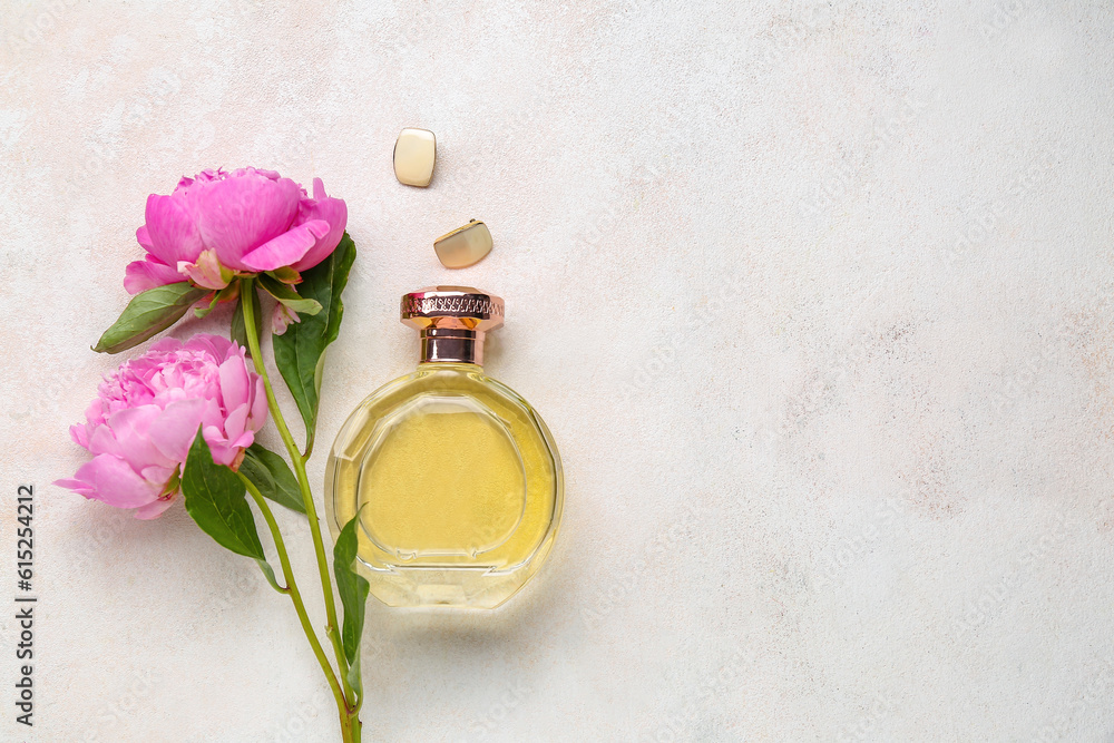 Bottle of perfume, earrings and beautiful peony flowers on light background