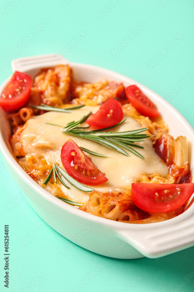 Baking dish of pasta with tomato sauce and cheese on blue background