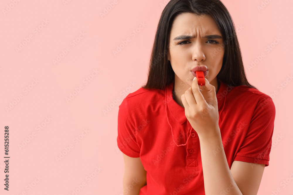 Female lifeguard whistling on pink background