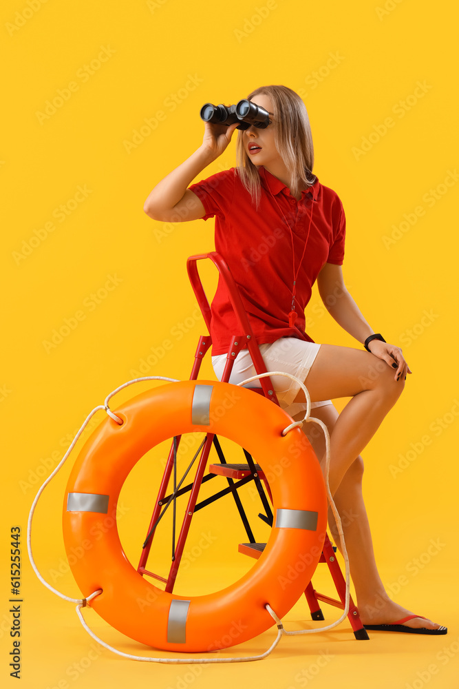 Female lifeguard with binoculars and ring buoy sitting on yellow background