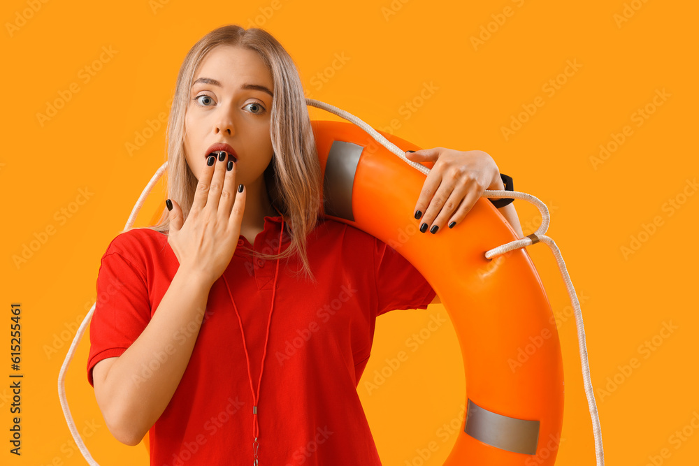 Shocked female lifeguard with ring buoy on yellow background