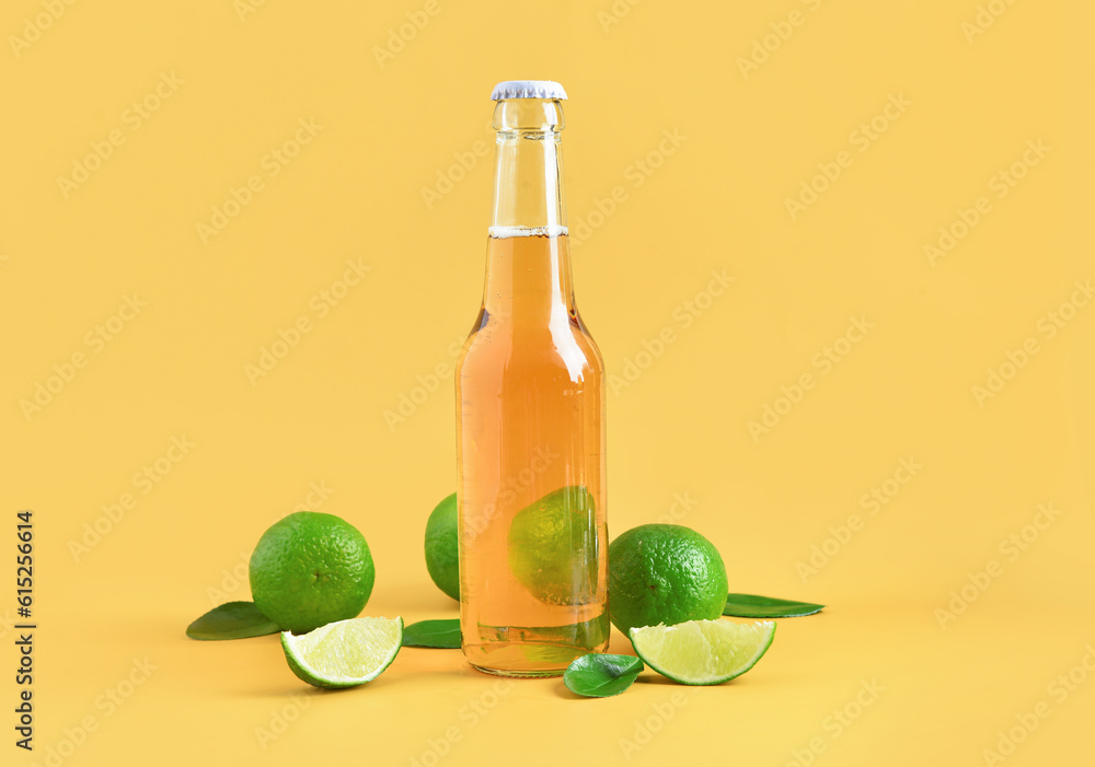 Bottle of cold beer with lime on yellow background