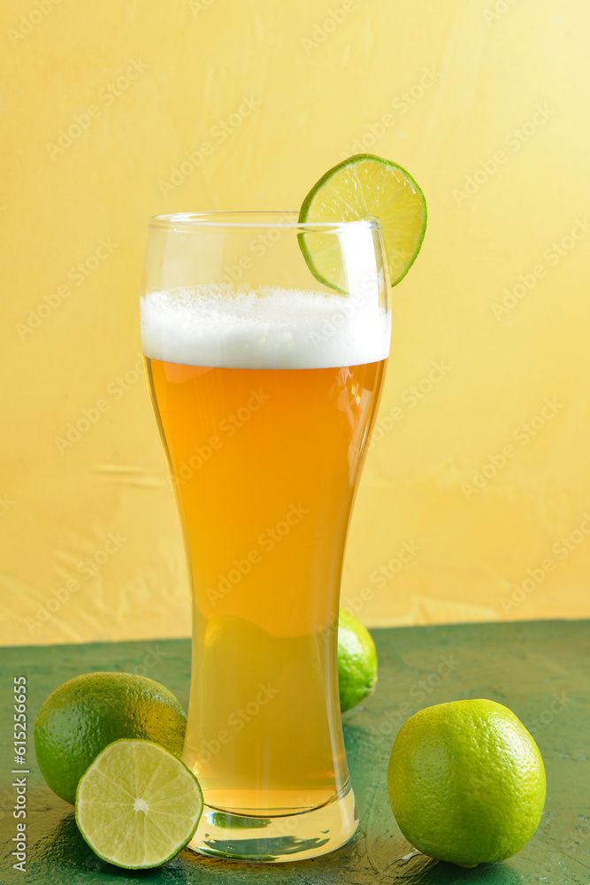 Glass of cold beer with lime on table