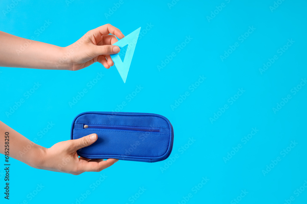 Woman with pencil case and ruler on blue background