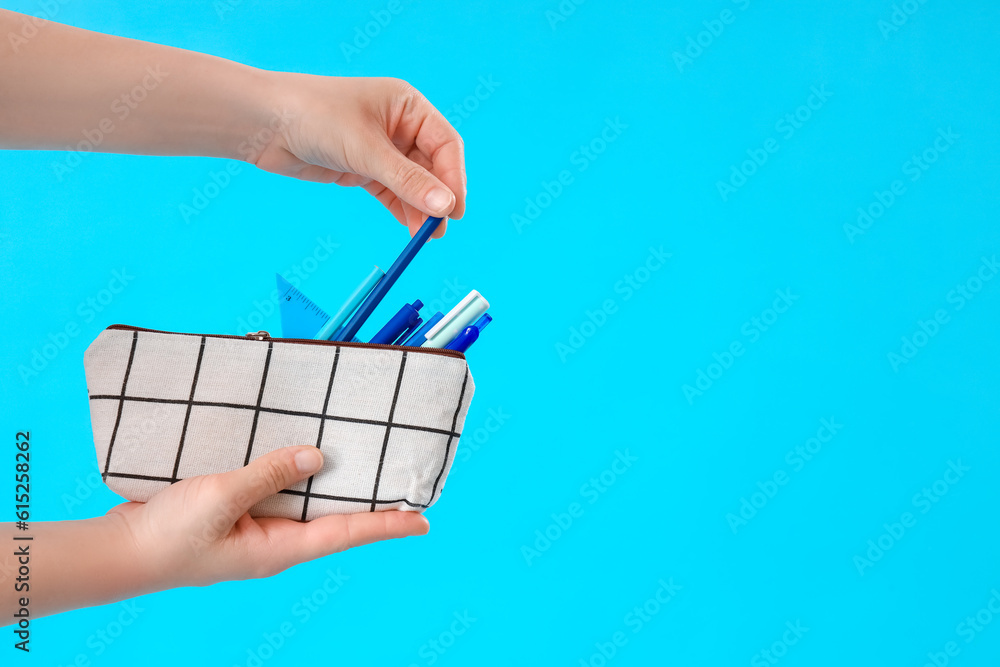 Woman with pencil case on blue background