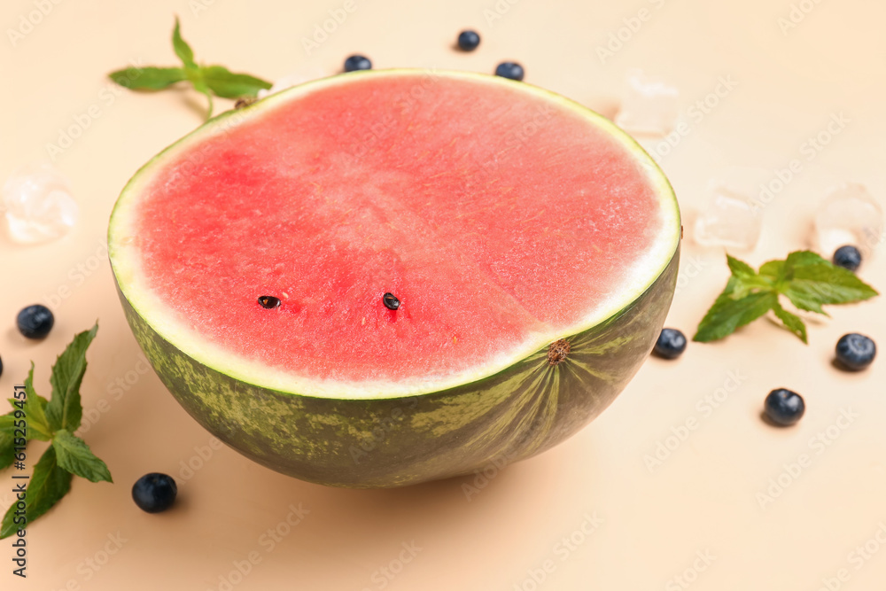 Half of fresh watermelon and blueberries on orange background