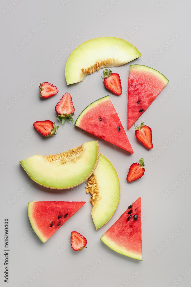 Pieces of fresh watermelon and different berries on grey background