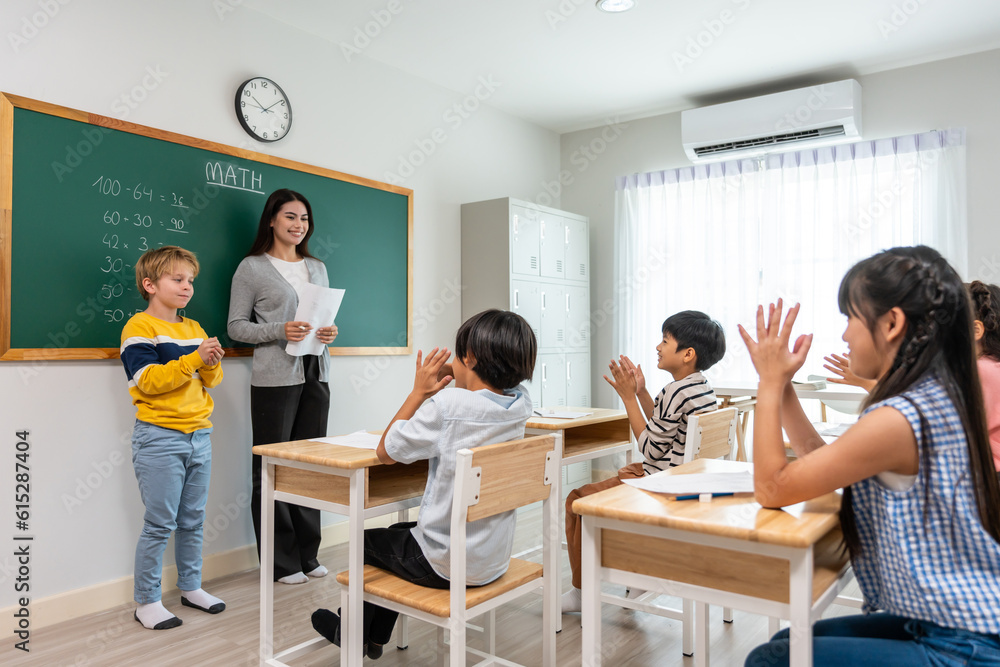 Group of student learn with teacher in classroom at elementary school. 