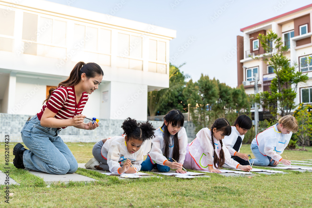 Group of student coloring on painting board outdoors in school garden. 