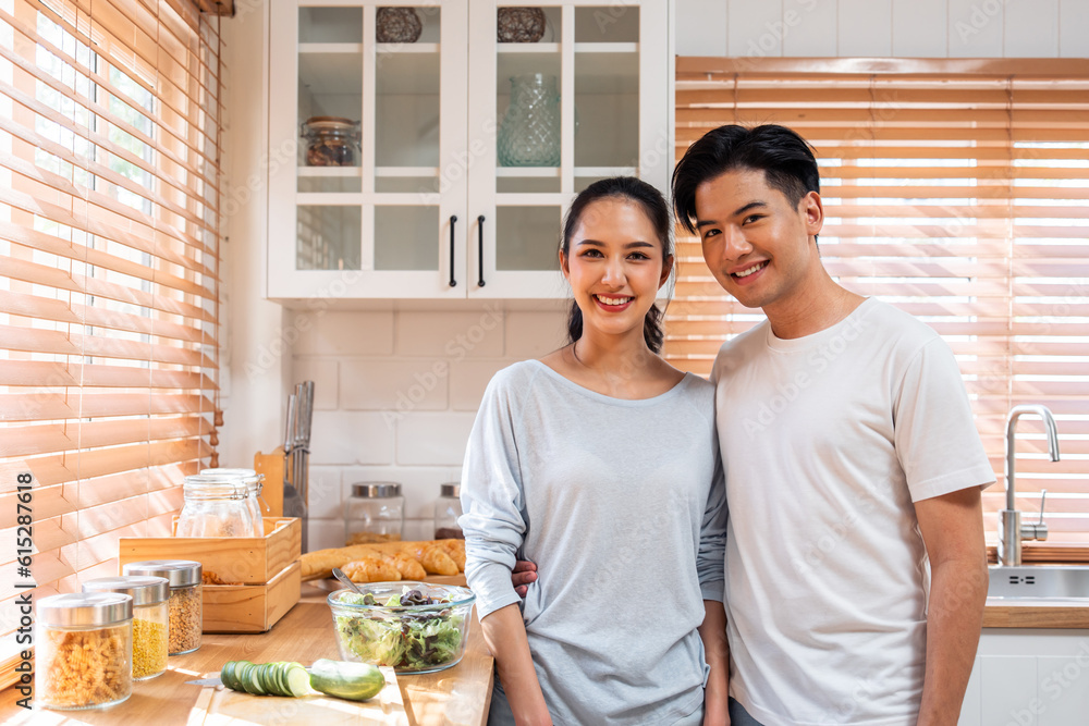 Portrait of Asian young man and woman standing together in the kitchen. 