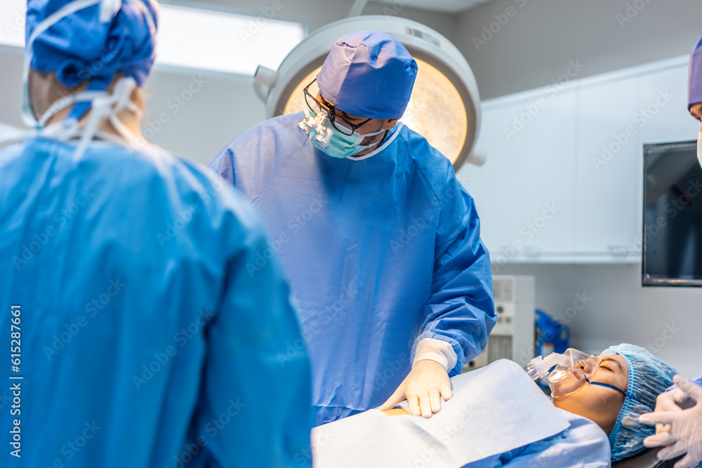 Professional doctors performing surgical operation in operating room.