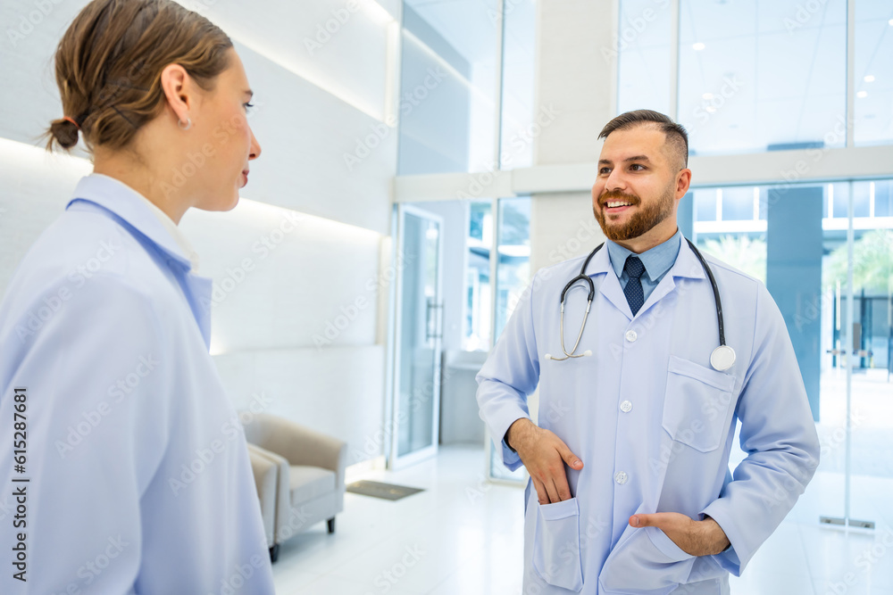 Caucasian doctors walk through hallway and talking together in hospital. 