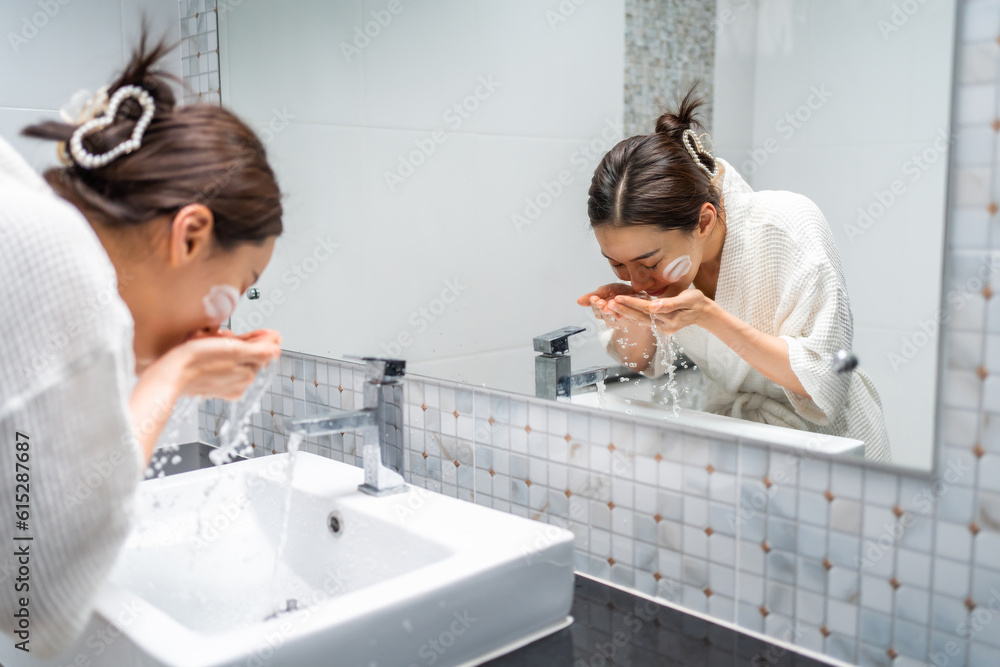 Asian beautiful woman washing her clean face with facial foam and water. 