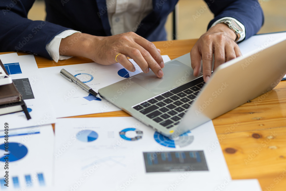 Businessman working on documents on the desk, data analysis of financial figures on laptop and busin