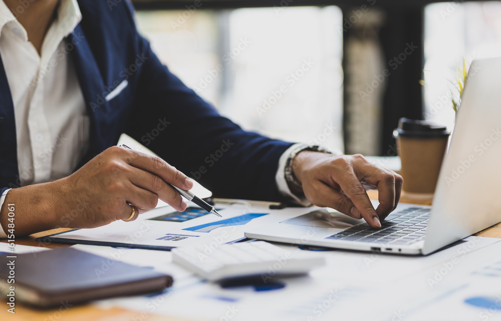 Businessman working on documents on the desk, data analysis of financial figures on laptop and busin