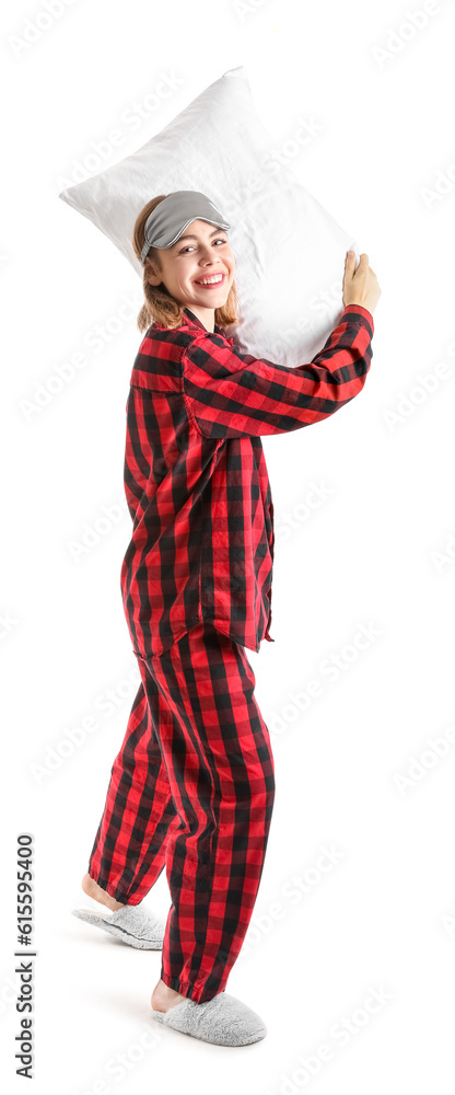 Young woman in checkered pajamas with pillow on white background