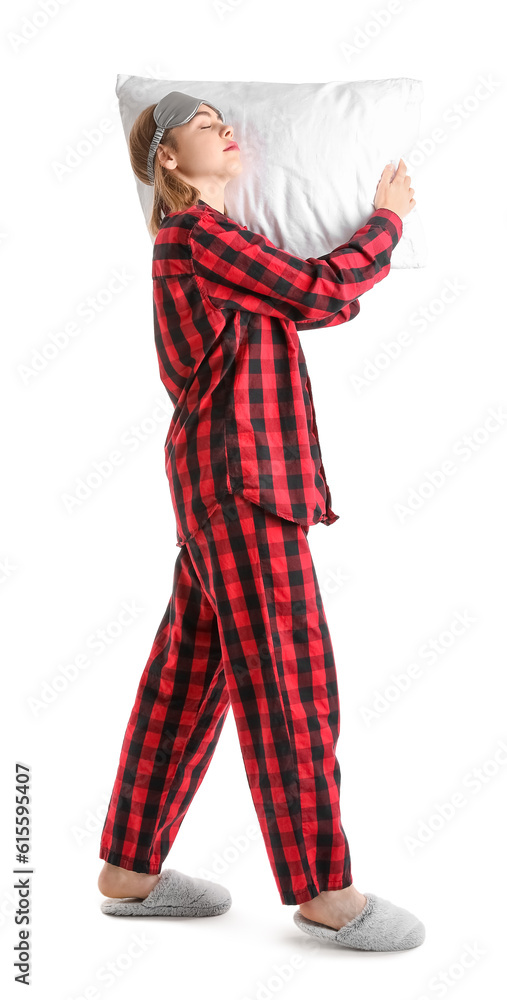 Young woman in checkered pajamas with pillow sleeping on white background