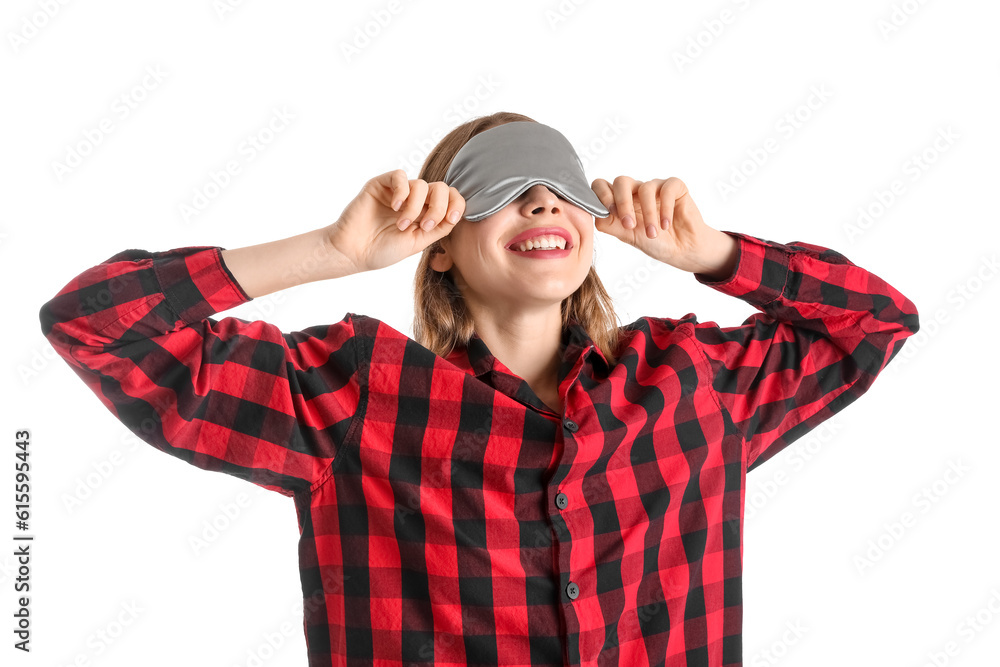 Young woman in sleeping mask and checkered pajamas on white background