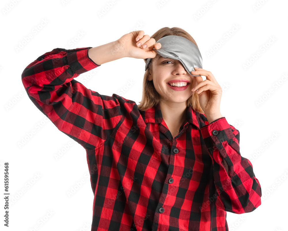 Young woman in sleeping mask and checkered pajamas on white background