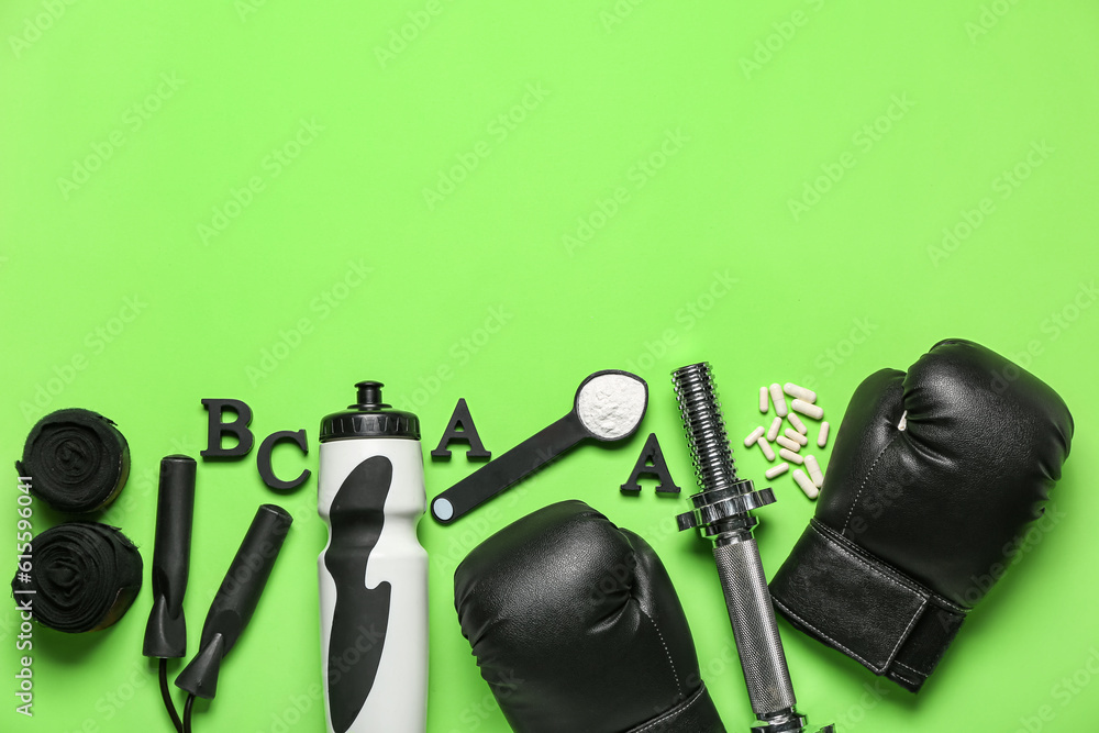 Composition with sports equipment, bottle of water and amino acid supplements on green background