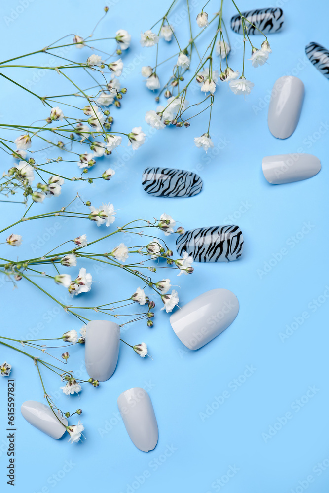 Press-on nails with flowers on blue background