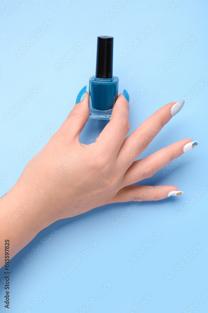 Woman with press-on nails and polish on blue background