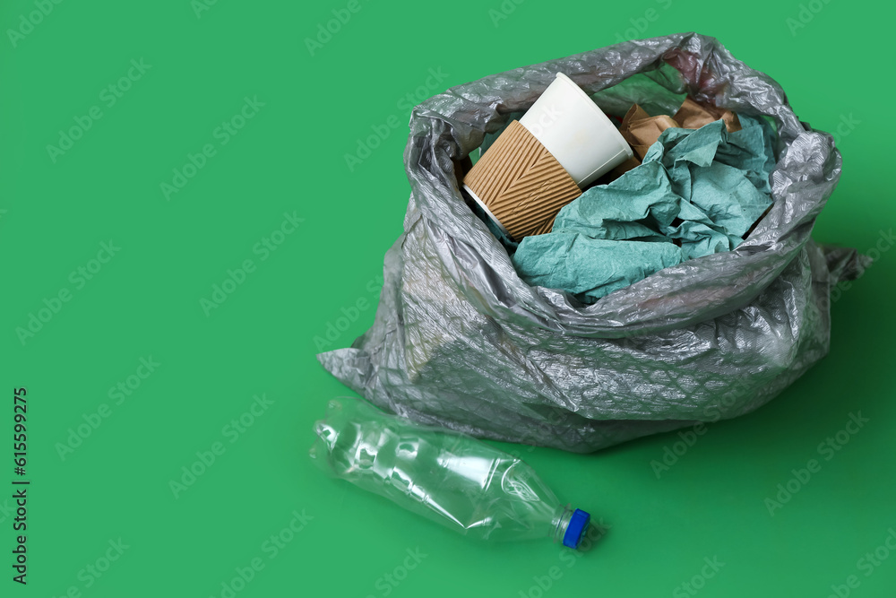 Full garbage bag on green background