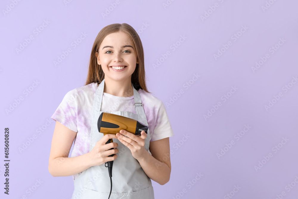 Female hairdresser with dryer on lilac background