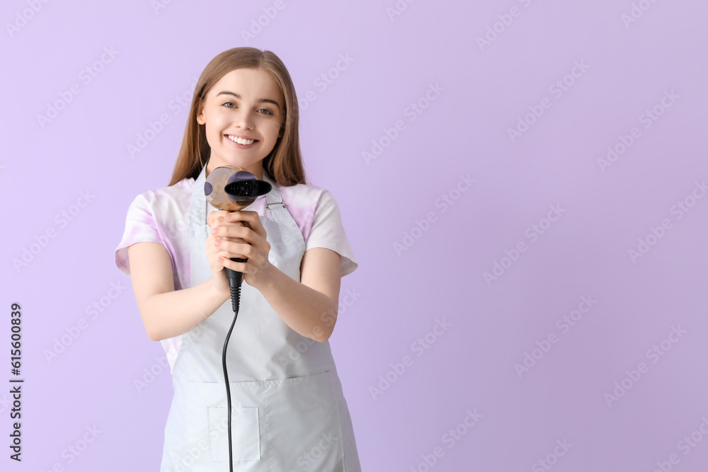 Female hairdresser with dryer on lilac background