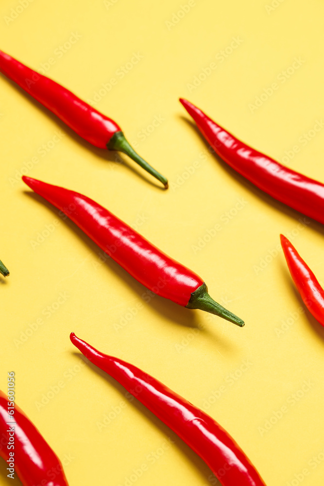 Fresh hot chili peppers on yellow background