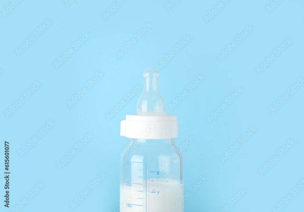 Bottle of milk for baby on blue background