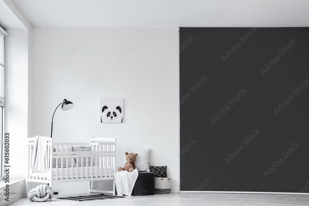 Stylish interior of childrens room  with baby bed and ottoman