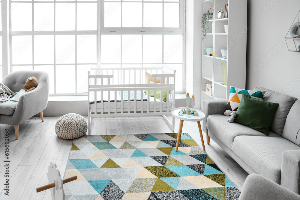 Stylish interior of childrens room with baby bed and shelving unit