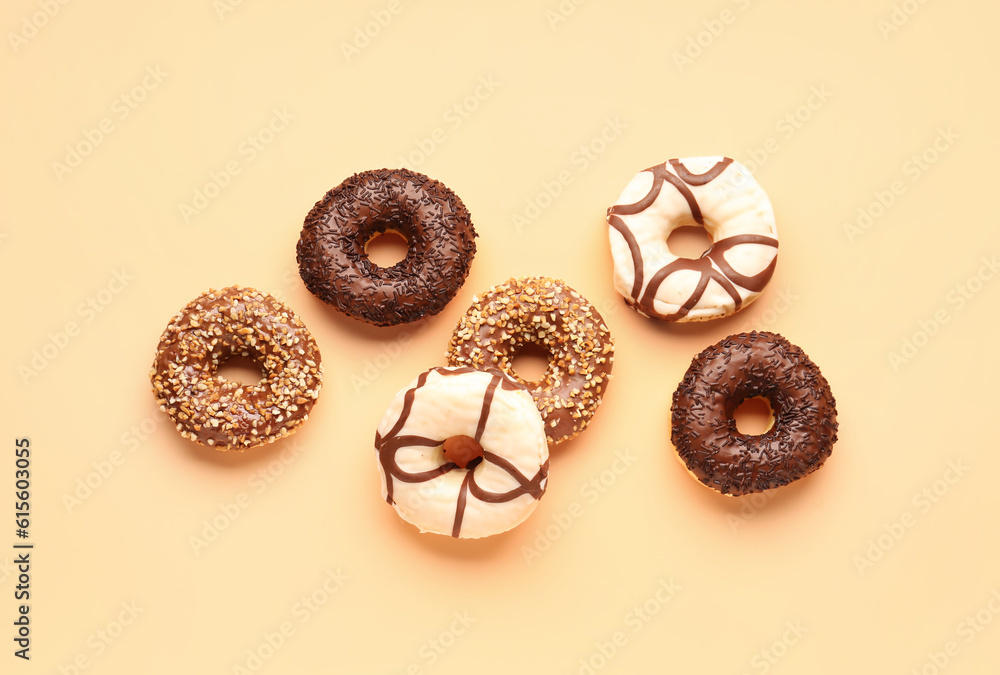 Sweet chocolate donuts on beige background