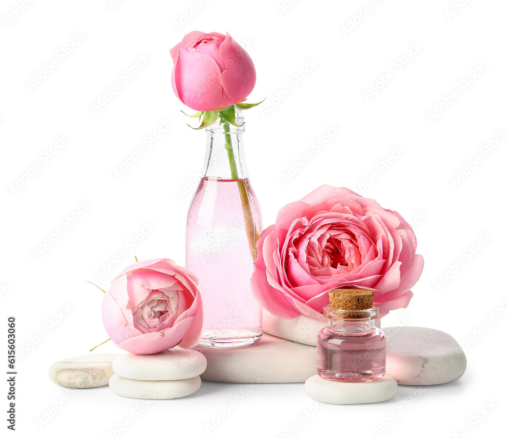 Bottles of cosmetic oil with rose extract and flowers on white background