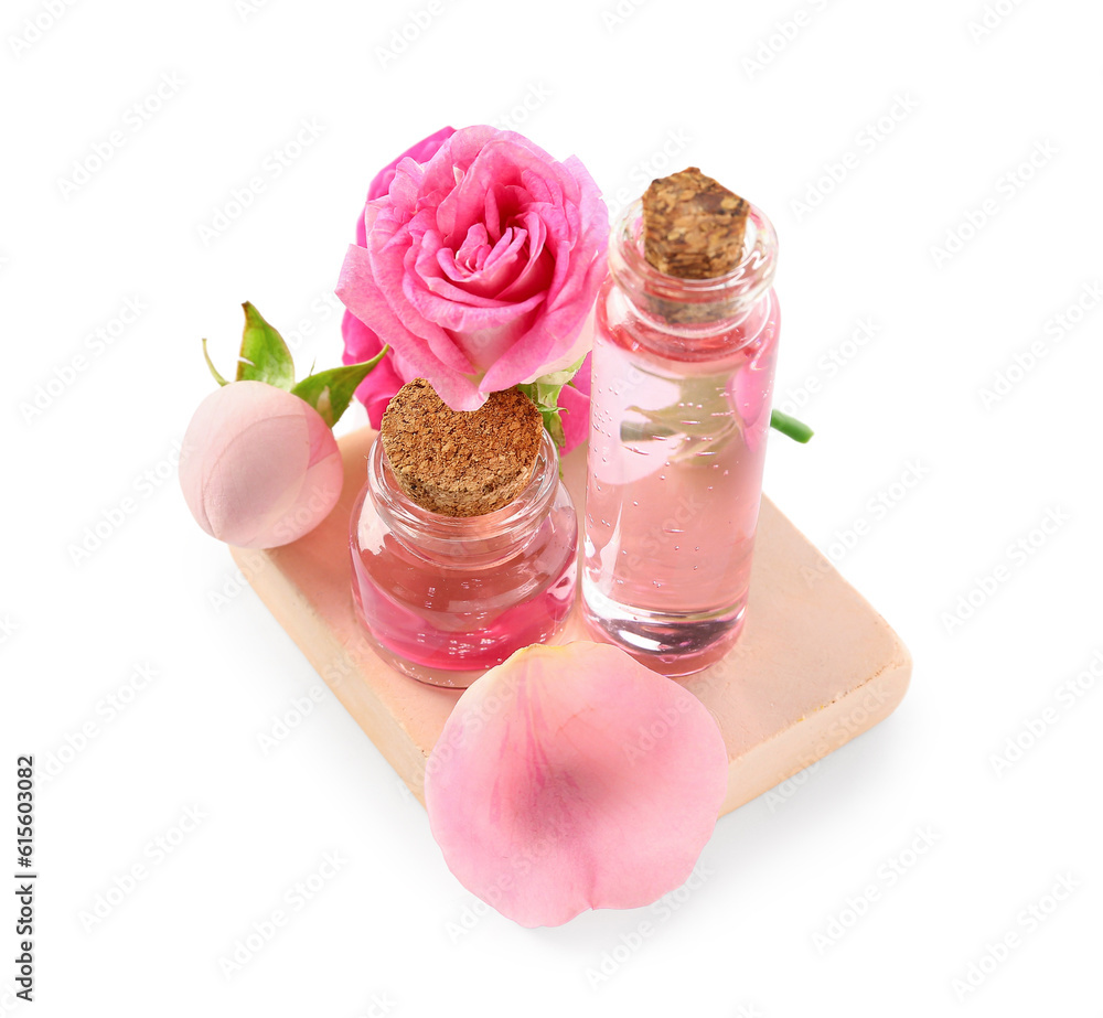 Bottles of cosmetic oil with rose extract and flowers on white background