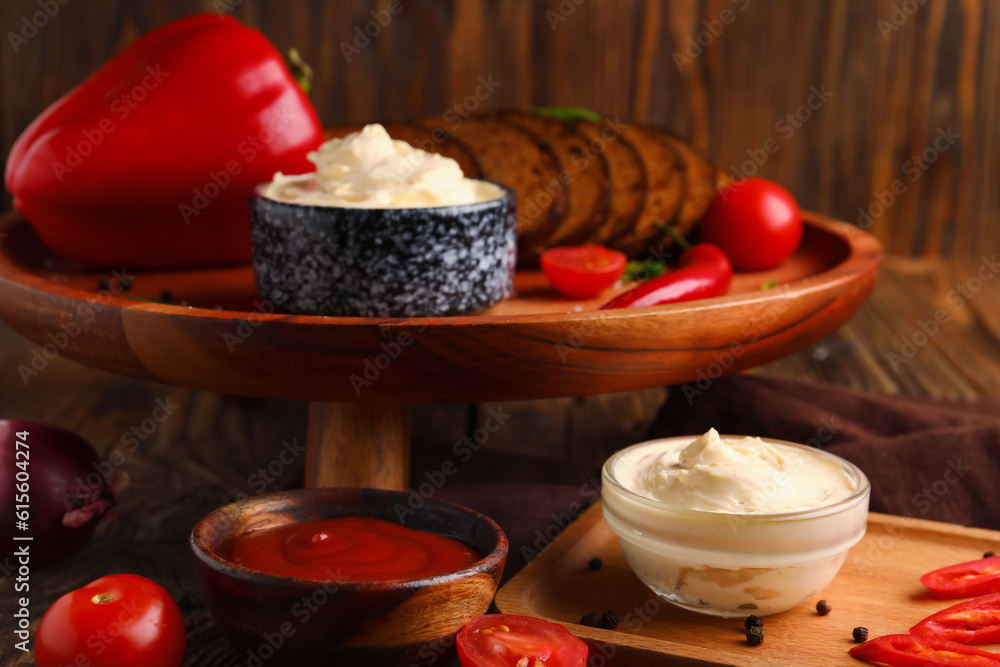 Bowls of tasty cream cheese and sauce on table