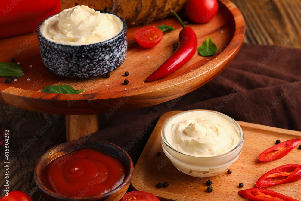 Bowls of tasty cream cheese and sauce on table