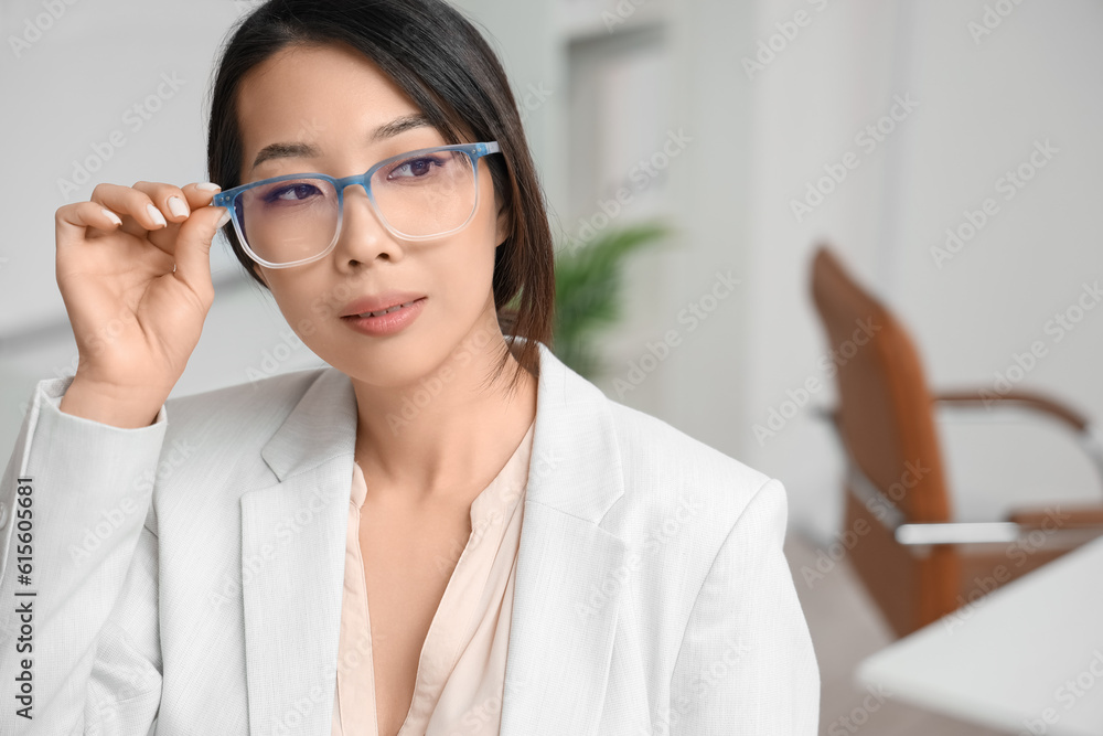 Beautiful Asian businesswoman in stylish eyeglasses in office, closeup