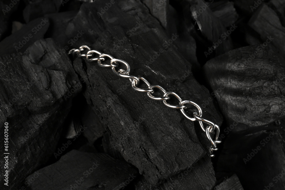 Beautiful chain bracelet on black charcoal, closeup